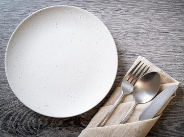 An empty plate with a knife and fork on the side