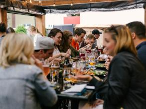 A group of people gathered around a table in a restaurant, eating